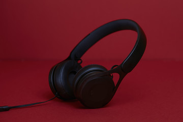 Fototapeta na wymiar Black headphones on a red background
