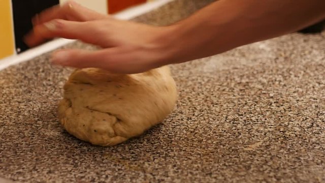 Extreme close up of a man's hand kneading and preparing the dough of artisan bread.