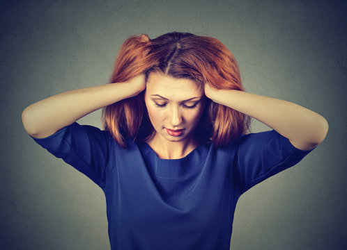 Stressed young woman with headache looking down