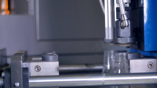 A high-speed motion of PET bottles manufacturing.