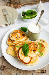 Pancakes with mushrooms and onions, served with sour cream and a green salad.