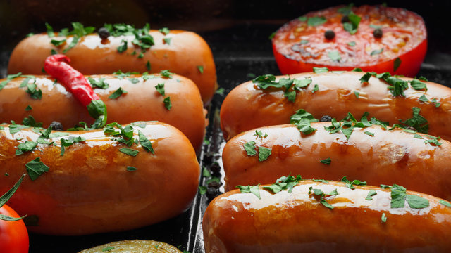 Fried sausages with herbs and vegetables in grill pan