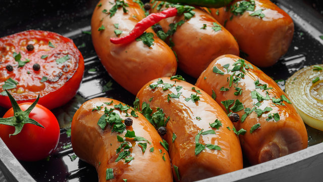 Fried sausages with herbs and vegetables in grill pan