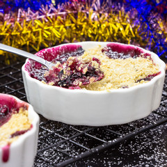 Two Homemade delicious crumble with berries in portioned individual ramekins. Christmas concept....