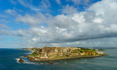 Fototapeta na wymiar Scenic view of historic colorful Puerto Rico city in distance with fort in foreground