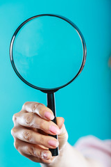 Woman hand holding magnifying glass