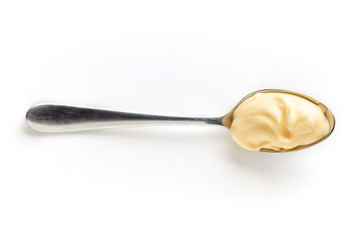 Mayonnaise in a spoon isolated on white, from above