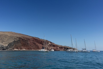 Red beach in Santorini view of the sea with katamaran