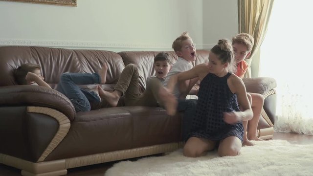 Young mother plays with sons at home