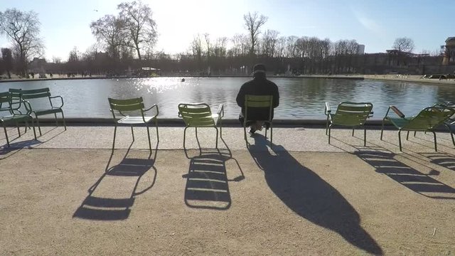 man relaxing on chair next to the pool or pond