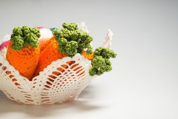 Handmade knitted vase with carrot isolated on white