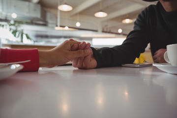 Cropped image of couple holding hands