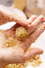 Cooking candy from dates, dried apricots and nuts, vertical, selective focus, hands in frame, ingredients