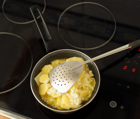 Preparación de una tortilla española, freir patatas con cebolla en aceite de oliva