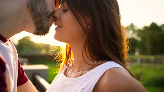 Young couple in love kissing on the street at sunset
