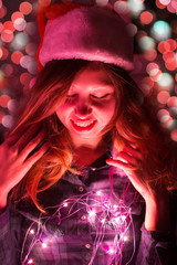 Girl with Christmas lights and Santa hat