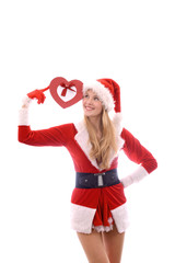 A young girl shows her happy feelimgs at Christmas time  with her present, a Christmas heart. Smilingly she stands in  front of a white background.