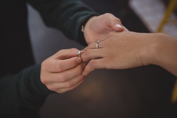 Cropped image of man putting ring on woman finger