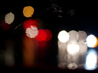 blurry traffic jam bokeh light view outside road from inside a car while raining , night cityscape of abstract background