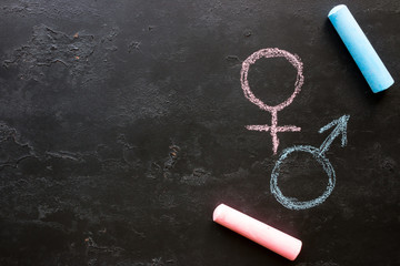 Male and female gender symbols on a black background with space for text