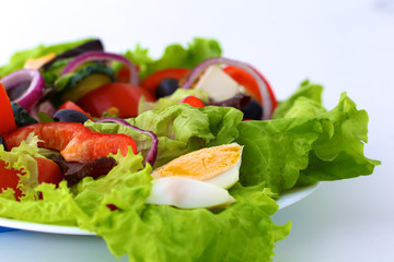 salad from fresh vegetables in a plate on a table, selective focus