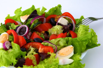 salad from fresh vegetables in a plate on a table, selective focus