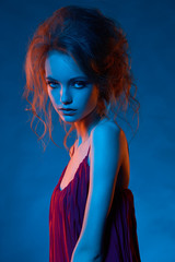 Portrait of beautiful girl in blue light and red light close up with hairstyle