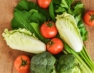 Organic vegetables for healthy eating.Tomatoes,Broccoli,Celery and Chinese cabbages on rustic wood background.