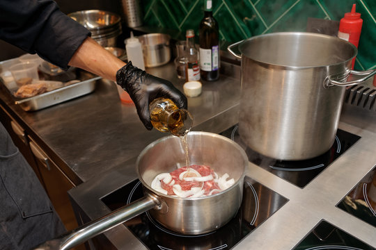Chef is adding white wine to a dish