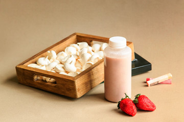 Strawberry milk in traditional bottles with straws on beige background