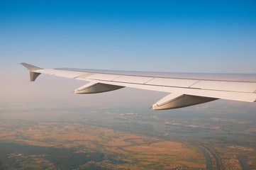 Fototapeta premium The wing of an airplane in the sky above the clouds.