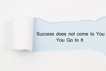 The motivational quote Success does not come to You, You Go to It appearing behind torn paper.