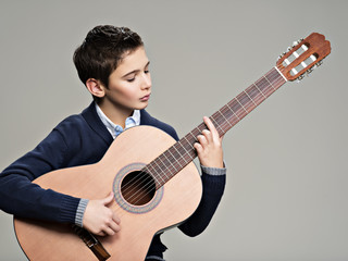 Obraz premium Caucasian boy playing on acoustic guitar.