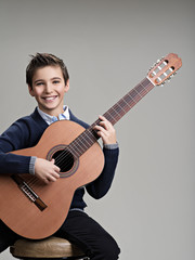 Obraz premium Happy boy playing on acoustic guitar.