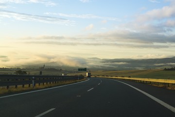 Fototapeta premium Misty morning sunrise on the road. Slovakia