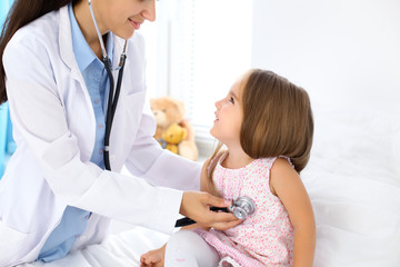 Obraz premium Doctor examining a little girl by stethoscope