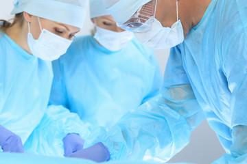 Medical team performing operation. Three of surgeons at work are busy of patient. Medicine, veterinary or healthcare and emergency in hospital