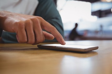 Cropped image of man touching mobile phone