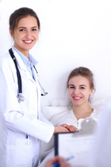 Female doctor smiling on the background with patient in the bed