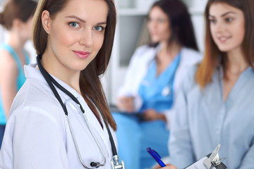 Young beautiful female doctor smiling to patient while consulting her