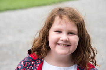 Young little girl portrait looking and smiling at the camera.