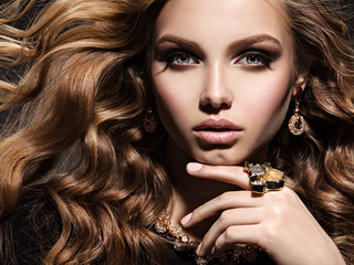 Beautiful woman with long curly hair and gold jewelry