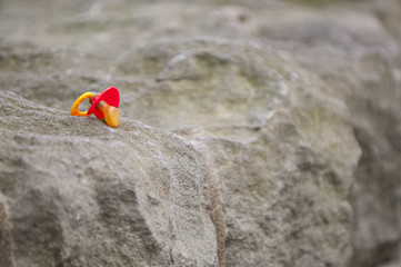 Obraz premium Abandoned red teat lying on the rock.