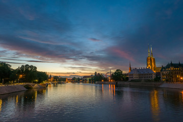 Fototapeta na wymiar Majestic vivid sky over the river and old town in Wrocław, Poland