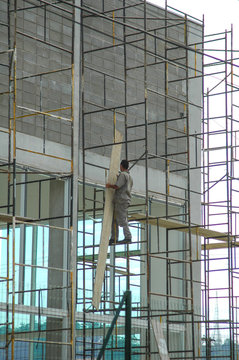 construction worker on scaffolding without harness or protective gear