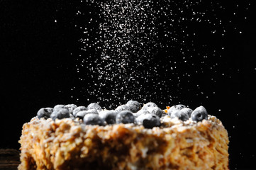 Napalion cake, pie, layered cake, puff cake with blueberry sprinkled with powdered sugar, on a rough wooden backing, menu background, close up, 