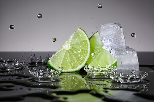 Fototapeta Plasterki limonki z kroplami wody i kostkami lodu