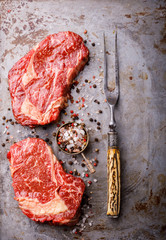 Raw Fresh Marbled Meat Beef Steak and Meat Fork  Seasonings on on the Gray Metal Background Pepper and Salt Ingredients for Cooking  Top View Copy space for Text