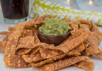 Bowl of Guacamole and Chips with Drink and Napkin in Background