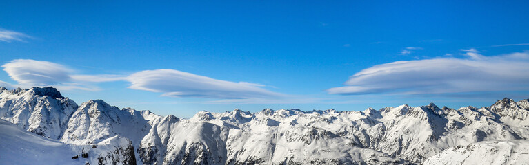 Fototapeta premium Panoramic landscape of ski resort valley with amazing beatiful mountains and dramatic cloudy sky on the background in Austria, Tyrol